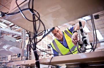 Hombre con chaleco amarillo trabajando en máquina