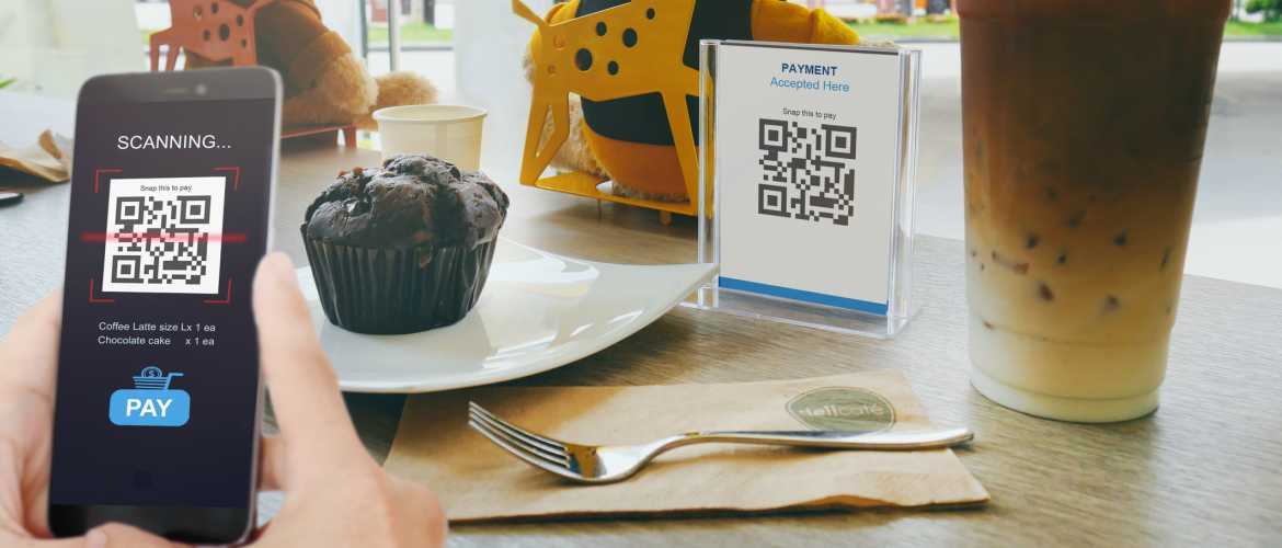 Persona escaneando código QR en cafetería